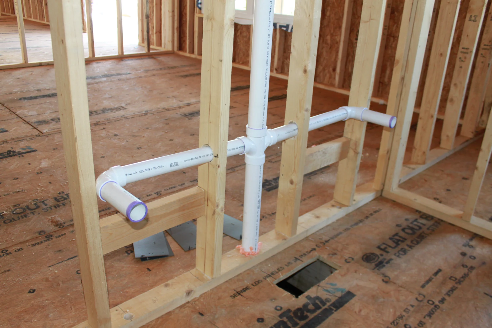Drain and vent rough-in routed through wall studs