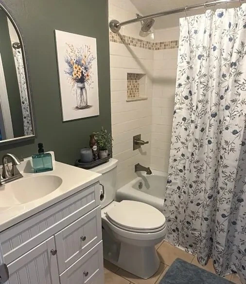 Bathroom with a vanity sink, toilet, and tiled tub and shower