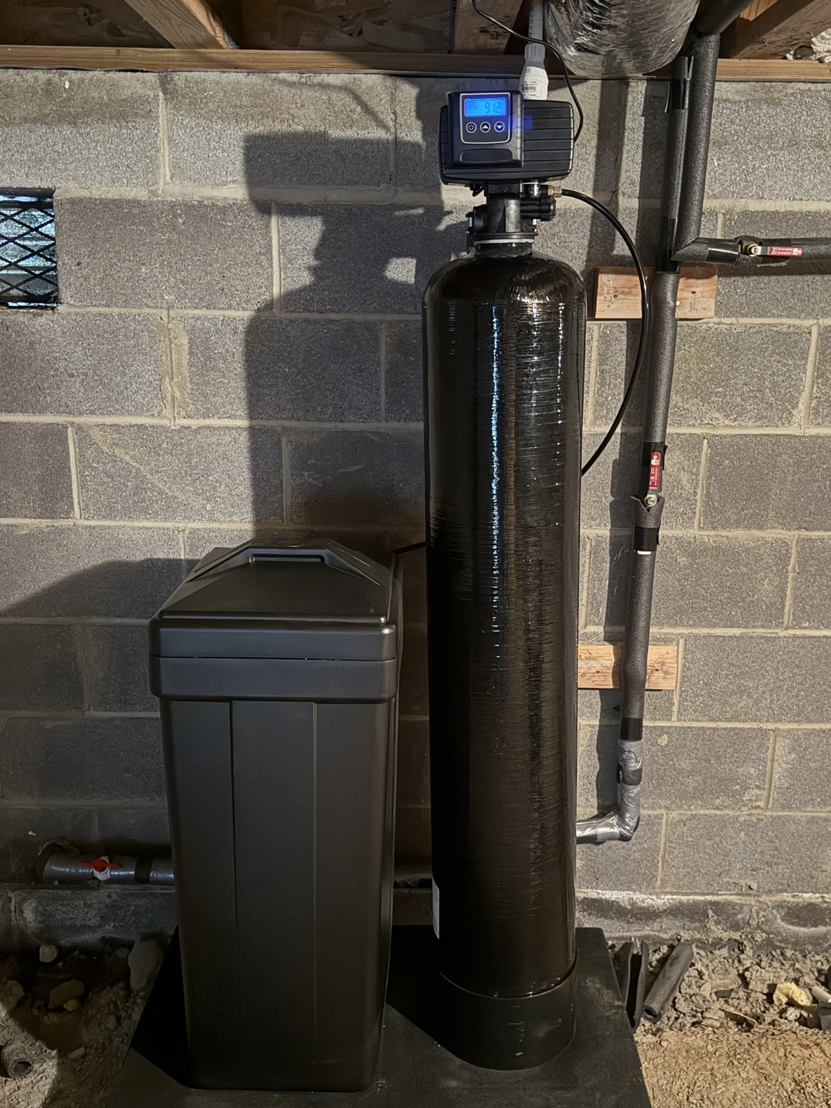Water softener and brine tank installed beside insulated water lines