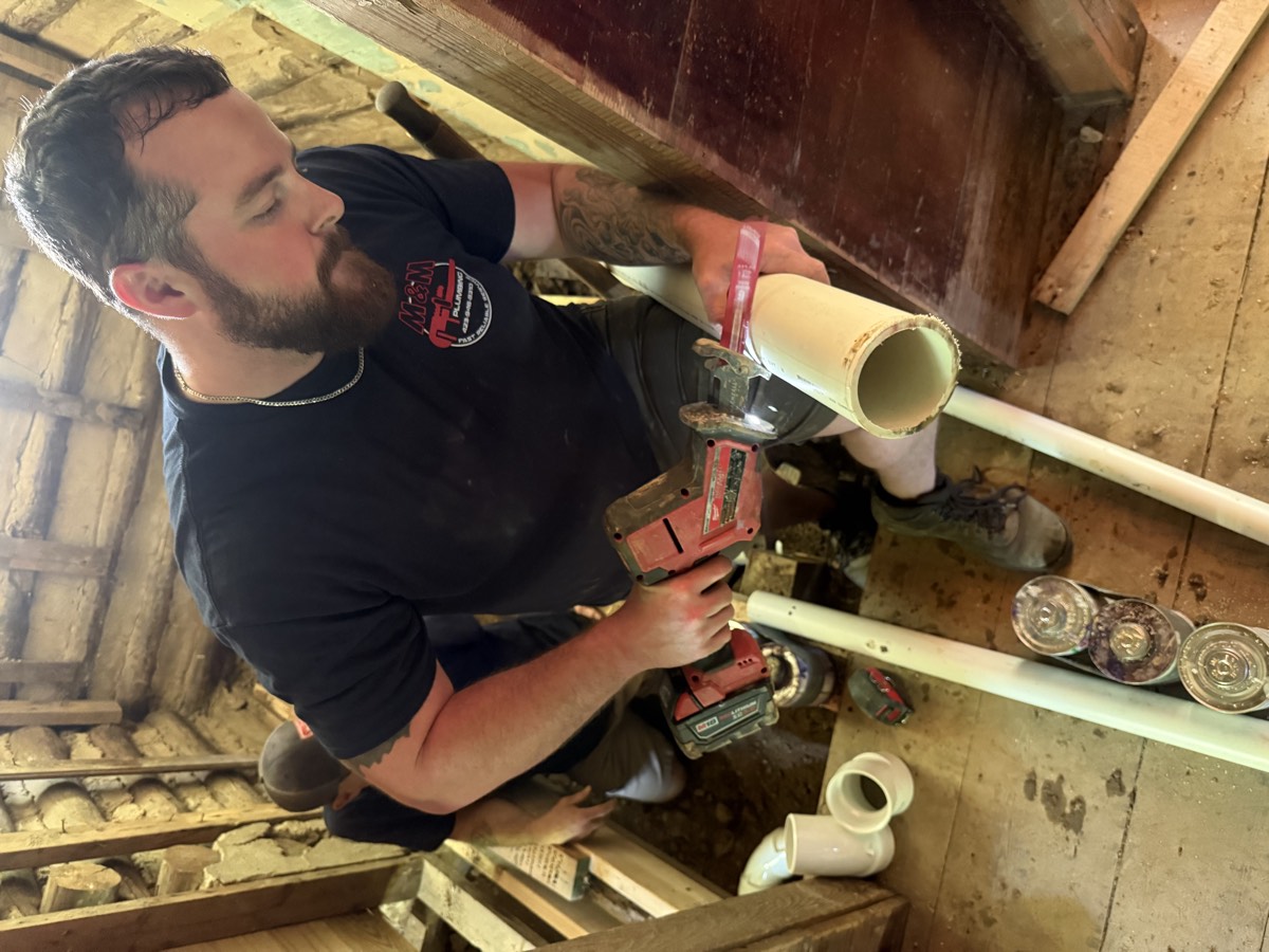 M & M Plumbing technician repairing a pipe on a residential job near Rogersville, TN