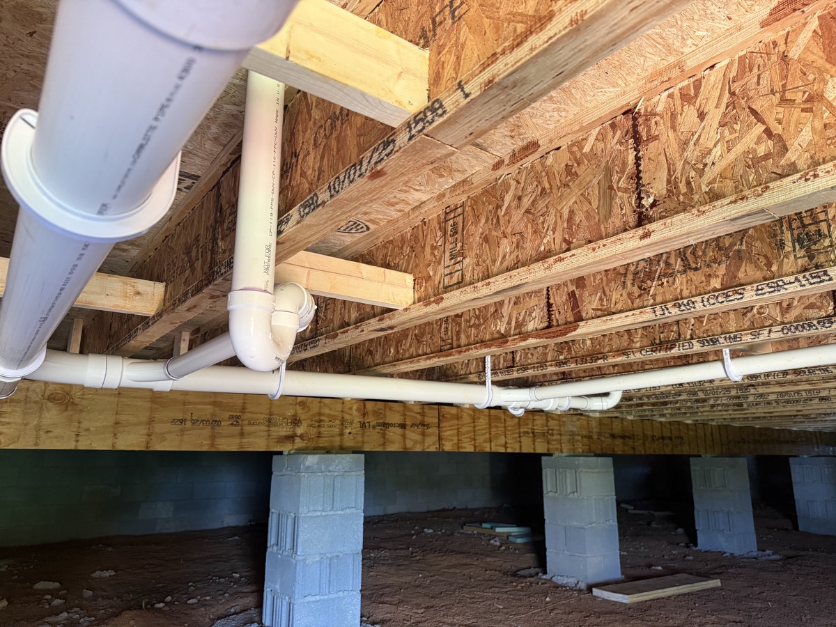 Neatly run PVC drain and waste lines in a crawlspace
